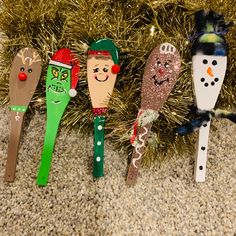 christmas ornaments made to look like toothpicks hanging from a fir tree with snowmen on them