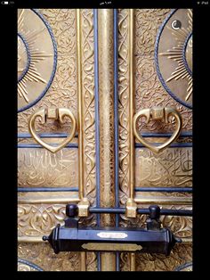 an ornate gold door with two black handles