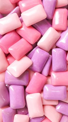 pink and purple candy pieces are stacked together on top of each other in this close up photo