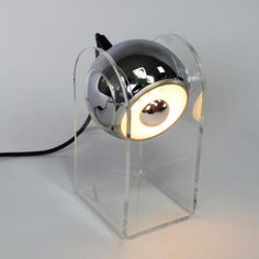 a lamp that is on top of a clear stand with a black and white light