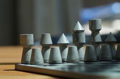 a set of marble chess pieces sitting on top of a wooden table next to a computer keyboard