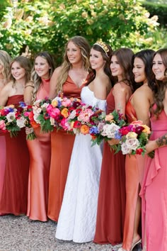 a group of women standing next to each other holding bouquets