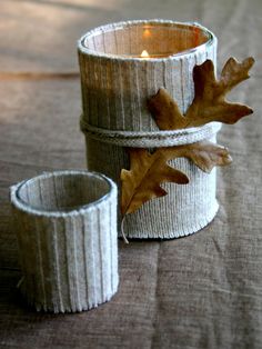 a candle holder made out of sweaters with leaves on the top and one in the middle