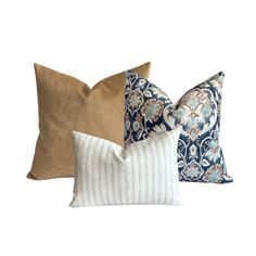 three pillows with different patterns on them, one in blue and the other in beige