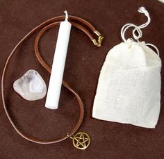 the contents of a necklace laid out on a brown surface with a white bag next to it