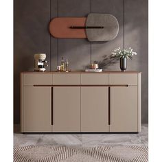 a modern sideboard with two vases and flowers on the counter top, in front of a gray wall