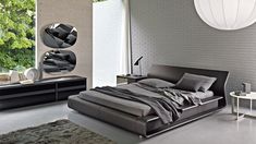 a modern bedroom with grey walls and white bricked wall, black leather bed frame