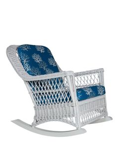 a white wicker rocking chair with blue cushions