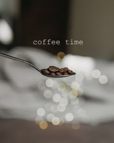 a spoon full of coffee beans with the words coffee time on it