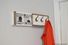 a coat rack with shoes hanging on it and an orange towel in front of it