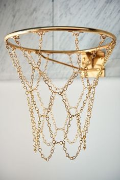 a gold chain chandelier hanging from the ceiling in a room with marble walls