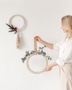 a woman is holding a wreath on the wall