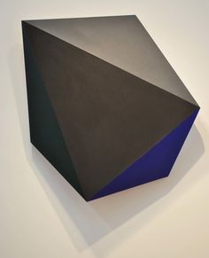 a black and blue object on a white wall