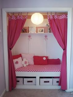 a pink and white day bed with curtains