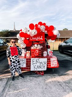 a woman in dalmatian clothing standing next to a truck with balloons on it