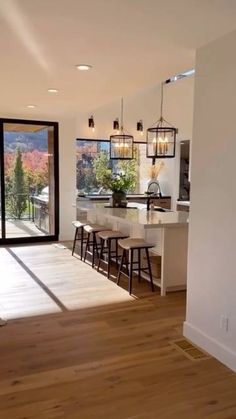 an open kitchen and dining room with sliding glass doors that lead to the outside patio