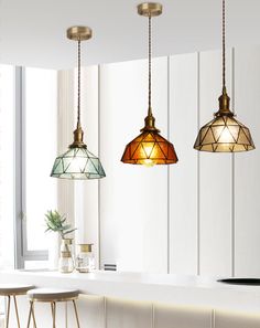 three lights hanging from the ceiling in a kitchen