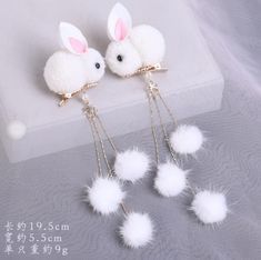 four white pom poms hanging from chains