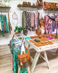 a clothing store with clothes and handbags on display