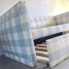 a blue and white checkered bed frame next to a wall