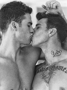 two men kissing each other with tattoos on their chests