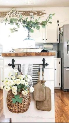 an open kitchen with white cabinets and flowers in a basket on the counter top, along with utensils