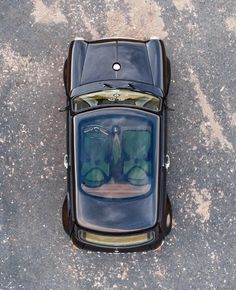 an aerial view of the back end of a car with its hood up and trunk open