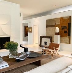 a living room filled with furniture and a fire place next to a wall mounted painting