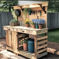 an outdoor potting station made out of pallets with flowers and gardening tools on top