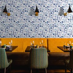 the restaurant is decorated with blue and yellow wallpaper, along with modern chairs and tables