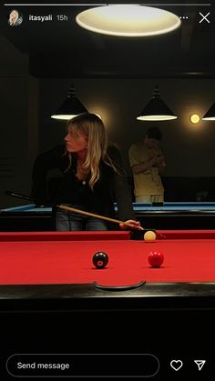 a woman is playing pool with friends in the background