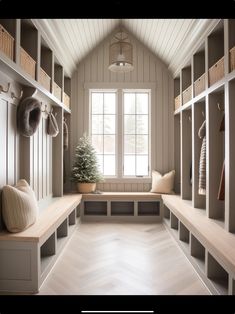 a room filled with lots of white shelves and wooden benches next to a large window