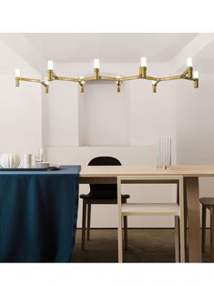 a dining room table and chairs with lights above them on the wall behind it is a blue table cloth