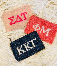 two personalized zipper pouches on white fur