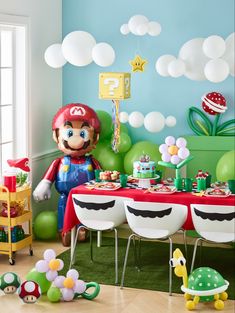 a mario birthday party with balloons, decorations and table cloths in the shape of toades