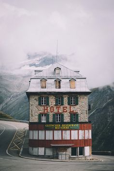 an old hotel with mountains in the background