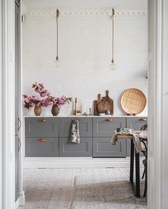 a kitchen with gray cabinets and white walls