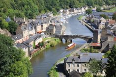 a river running through a small town next to a bridge with lots of buildings on it