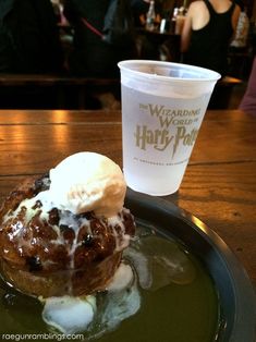 a pastry with ice cream on top sits on a plate next to a drink