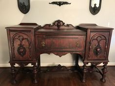 an old wooden desk with two mirrors on the wall