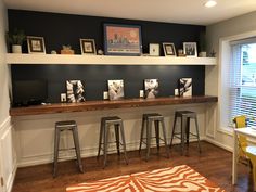 a room with some stools and pictures on the wall