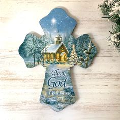 a cross shaped ornament with the words glory to god on it and a christmas scene