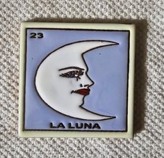 a lapel with a woman's face and the word la luna on it