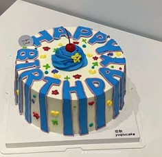 a blue and white birthday cake with the words happy birthday on it's top