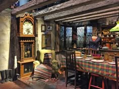 a room filled with lots of furniture next to a tall wooden clock mounted on the wall