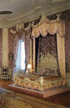 an ornately decorated bedroom is shown in gold and purple colors, with intricate drapes on the windows