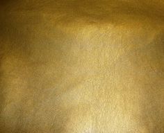 a close up view of a shiny gold leather textured surface with some slight highlights