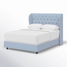 a blue bed with white sheets and pillows