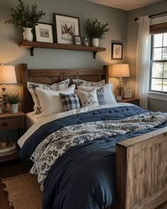 a bed with blue comforter and pillows in a bedroom next to a window,