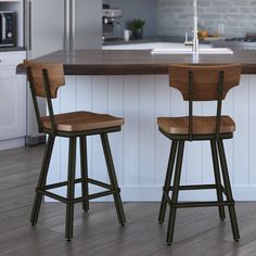 two wooden stools sitting in front of a kitchen island